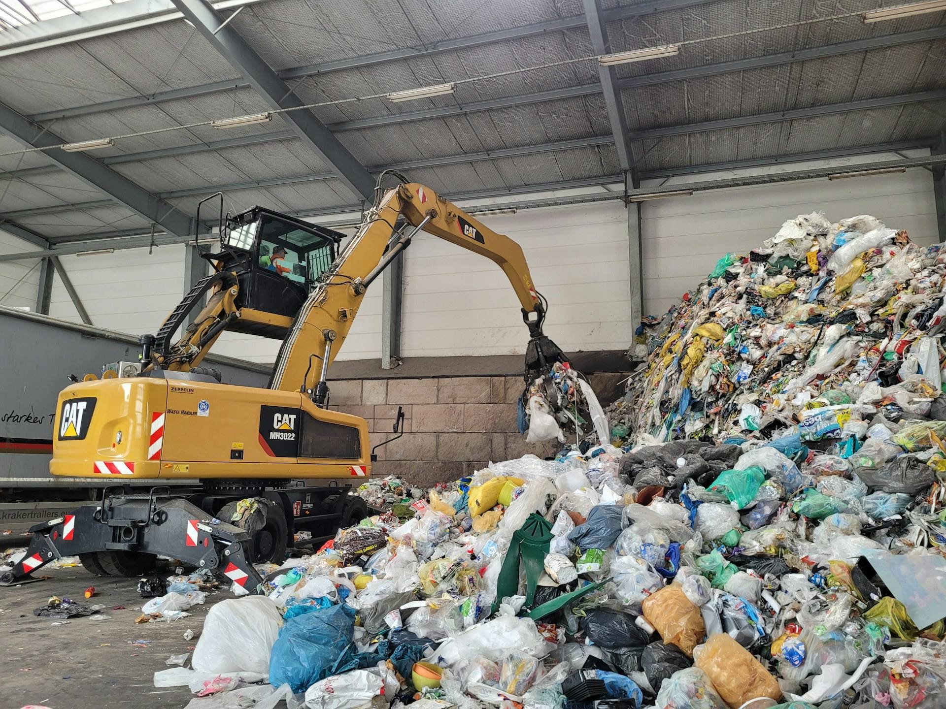 Greiferlader sortiert Baustoffe in der Recyclinghalle