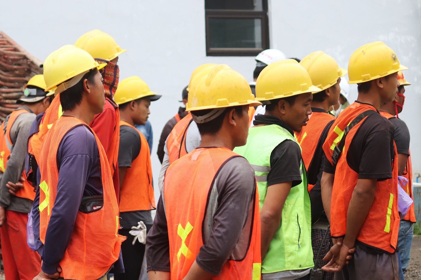 Kolonne in Helmen und Warnwesten — das Team auf der Baustelle